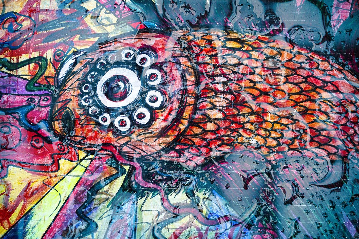 Mural de colores vibrantes con un pez de escamas rojas y naranjas y un gran ojo circular