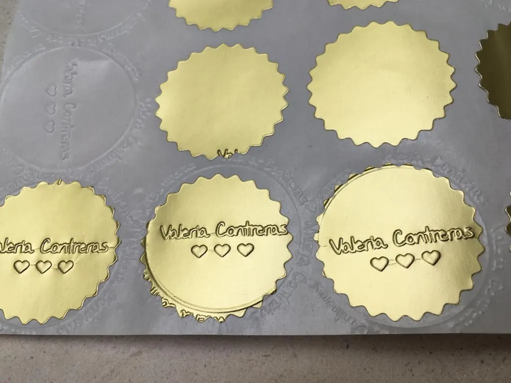 Sellos dorados con relieve que dicen Valeria Contreras y tres corazones
