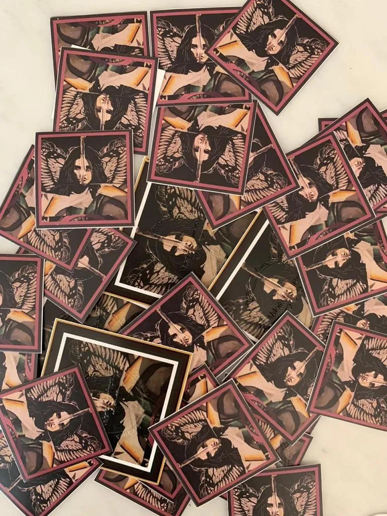 Montón de stickers impresos con una de sus obras en tonos rojos